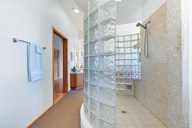 bathroom featuring walk in shower, vanity, and tile flooring