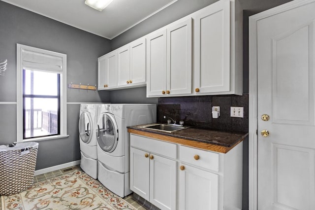 laundry area with light tile flooring, washer and dryer, cabinets, and sink