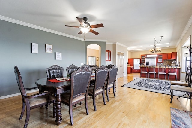 dining area with ornamental molding, ceiling fan with notable chandelier, and light hardwood / wood-style flooring