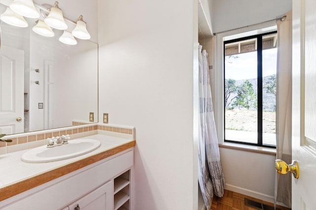 bathroom featuring vanity, parquet floors, and a chandelier