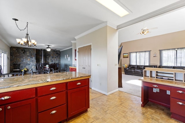 kitchen featuring light stone countertops, ceiling fan with notable chandelier, pendant lighting, light parquet flooring, and ornamental molding