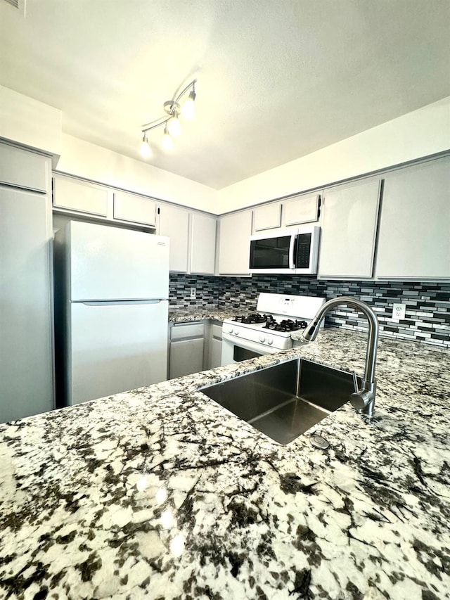 kitchen featuring gray cabinets, white gas stove, refrigerator, and sink