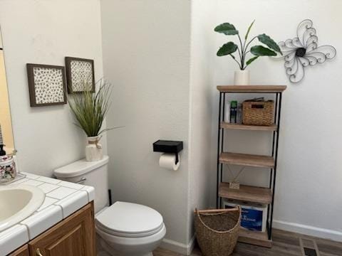 bathroom featuring vanity, toilet, and hardwood / wood-style floors