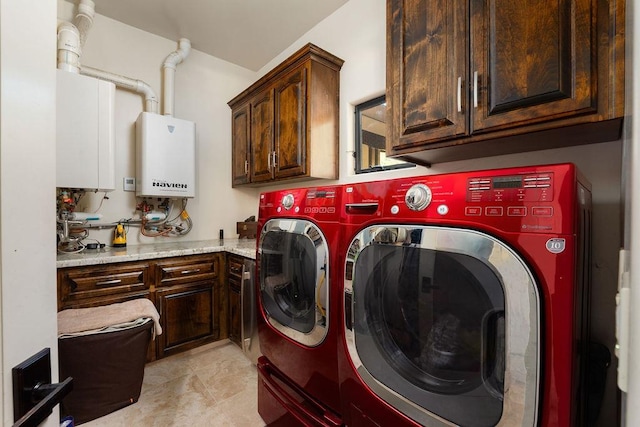 clothes washing area featuring washer and dryer, cabinets, water heater, and light tile floors