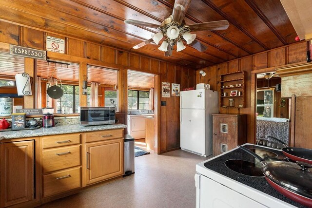 kitchen featuring ceiling fan, white fridge, range, wood ceiling, and wooden walls