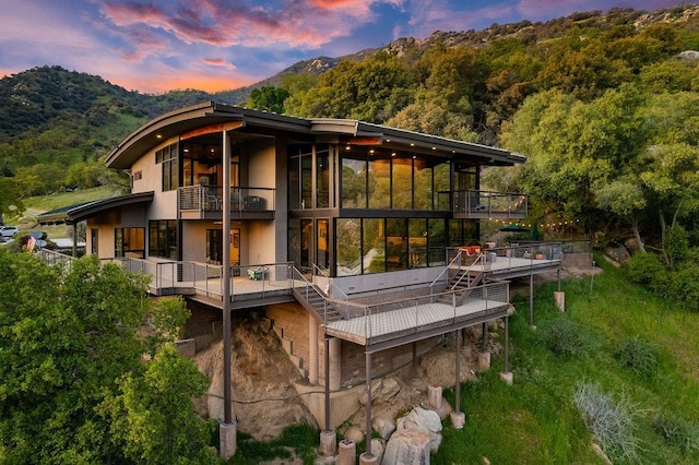 back house at dusk with a balcony