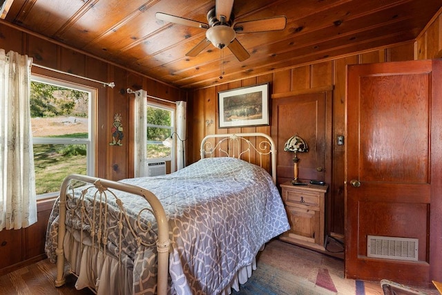 bedroom featuring wood walls, dark hardwood / wood-style flooring, ceiling fan, and wooden ceiling