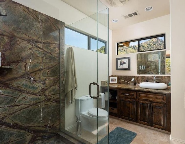 bathroom with an enclosed shower, vanity, tile floors, and toilet