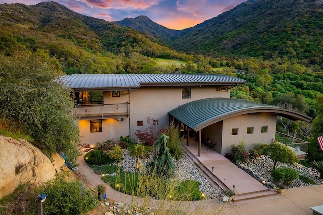 view of front of home featuring a mountain view and a balcony