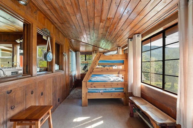 unfurnished bedroom featuring wood ceiling, wood walls, and multiple windows