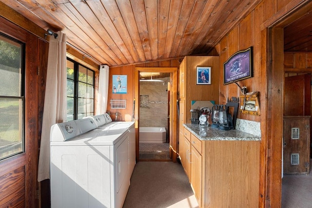 laundry room featuring washer and dryer, wooden ceiling, wood walls, and carpet