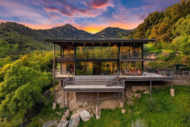 back house at dusk with a balcony