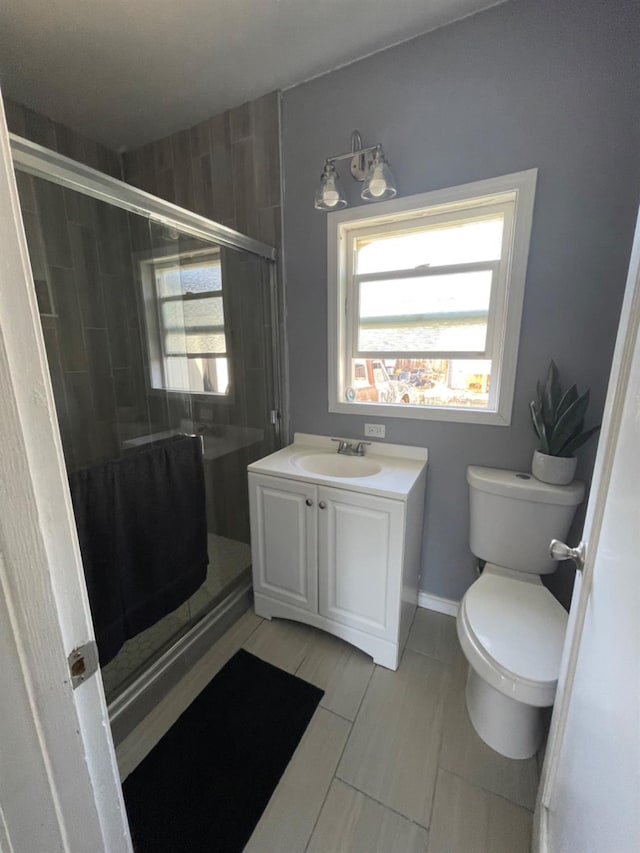 bathroom featuring vanity, toilet, and an enclosed shower