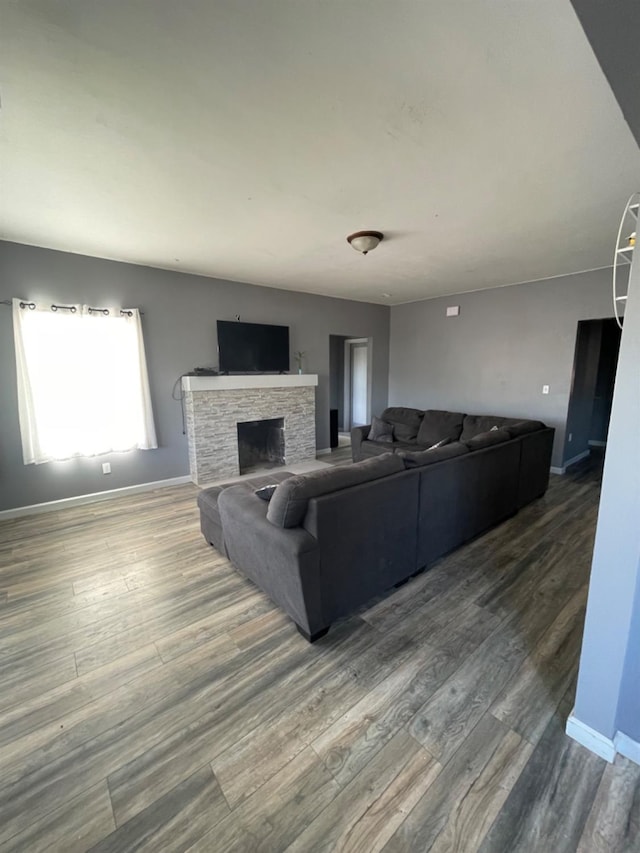 living room with wood-type flooring and a stone fireplace