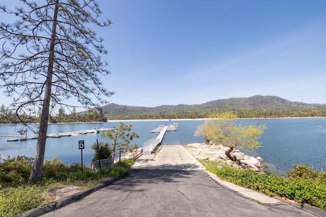 property view of water featuring a mountain view and a dock