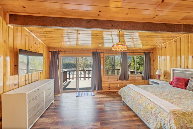 bedroom featuring wooden walls, dark hardwood / wood-style flooring, access to exterior, and multiple windows