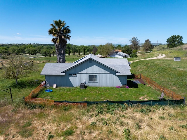 view of side of property featuring a lawn, cooling unit, and fence