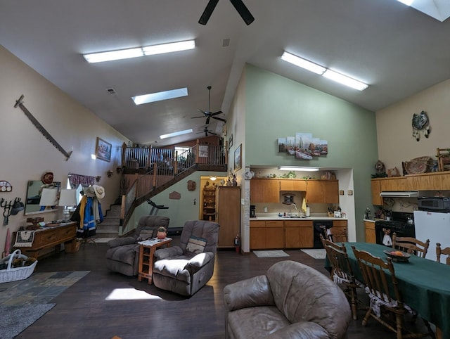 living room with high vaulted ceiling, dark wood-style floors, a skylight, ceiling fan, and stairs