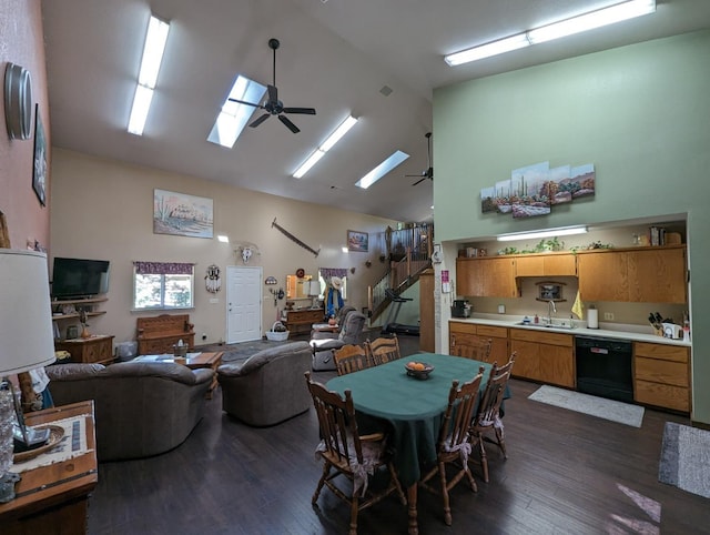 dining area with a skylight, high vaulted ceiling, ceiling fan, and dark wood-style flooring