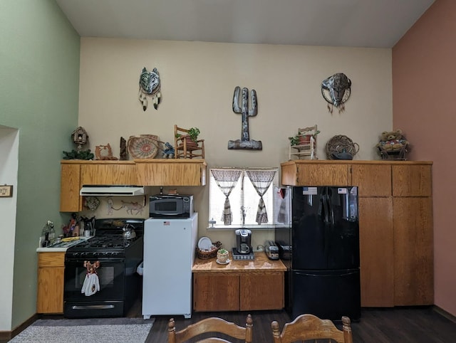 kitchen featuring black appliances, exhaust hood, light countertops, and baseboards