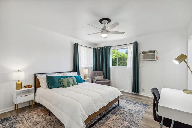 925 S Purdue Ave, Fresno, CA 93727 - bedroom featuring an AC wall unit, light wood-style flooring, a ceiling fan, and baseboards