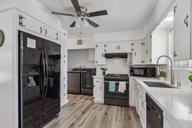 925 S Purdue Ave, Fresno, CA 93727 - kitchen with washing machine and dryer, black appliances, a sink, exhaust hood, and ceiling fan