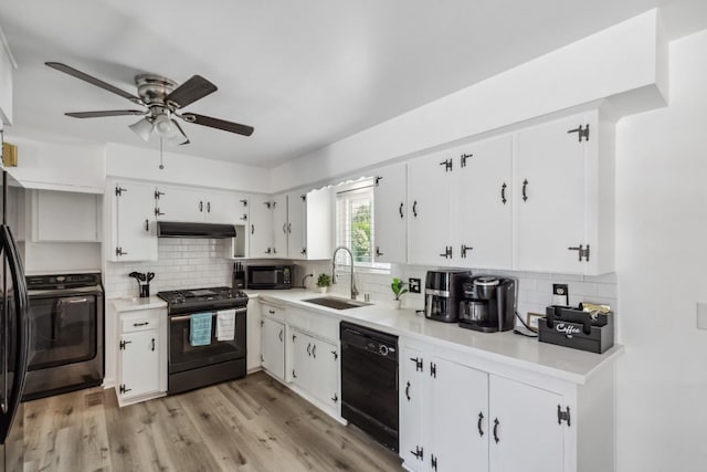 925 S Purdue Ave, Fresno, CA 93727 - kitchen featuring black appliances, under cabinet range hood, a sink, washer / clothes dryer, and decorative backsplash