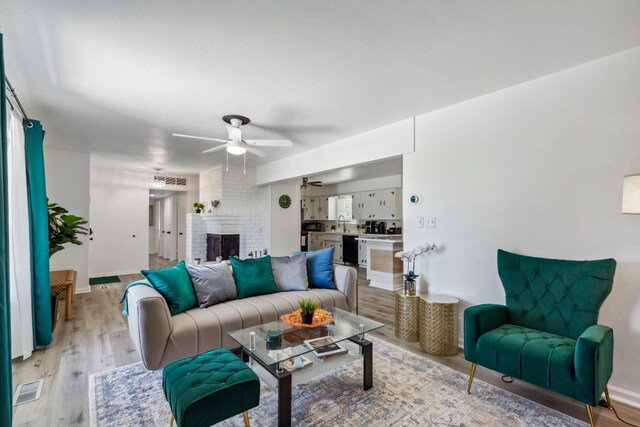 925 S Purdue Ave, Fresno, CA 93727 - living area with ceiling fan, light wood-style floors, a fireplace, and baseboards