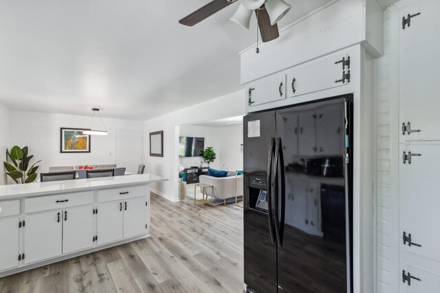 925 S Purdue Ave, Fresno, CA 93727 - kitchen with black fridge with ice dispenser, white cabinets, light wood finished floors, light countertops, and a ceiling fan