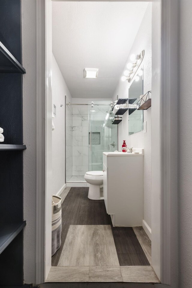 925 S Purdue Ave, Fresno, CA 93727 - full bathroom featuring toilet, vanity, a stall shower, and wood finished floors
