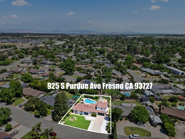 925 S Purdue Ave, Fresno, CA 93727 - aerial view of residential area with property boundaries highlighted, a pool area, and a mountain backdrop