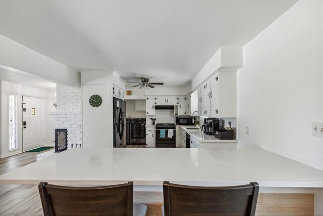 925 S Purdue Ave, Fresno, CA 93727 - kitchen featuring black appliances, a ceiling fan, light countertops, a peninsula, and a sink