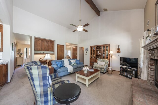 living room with high vaulted ceiling, a brick fireplace, beam ceiling, ceiling fan, and light colored carpet