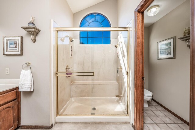 bathroom featuring a shower with shower door, vanity, lofted ceiling, toilet, and tile patterned floors