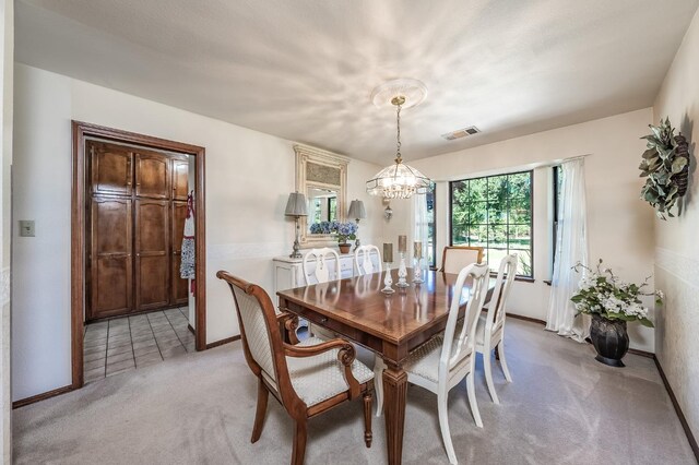 carpeted dining area with a notable chandelier