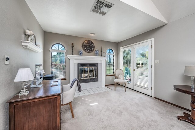 carpeted office featuring a tiled fireplace