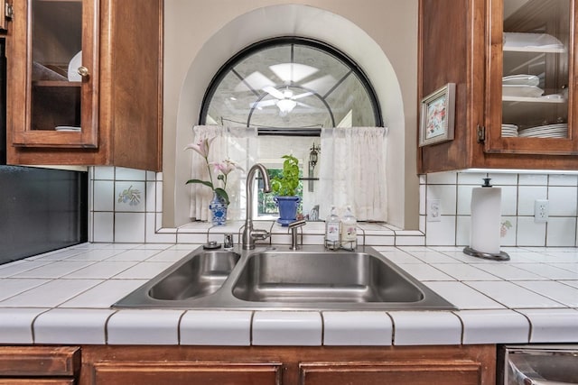 kitchen featuring stainless steel dishwasher, sink, and decorative backsplash