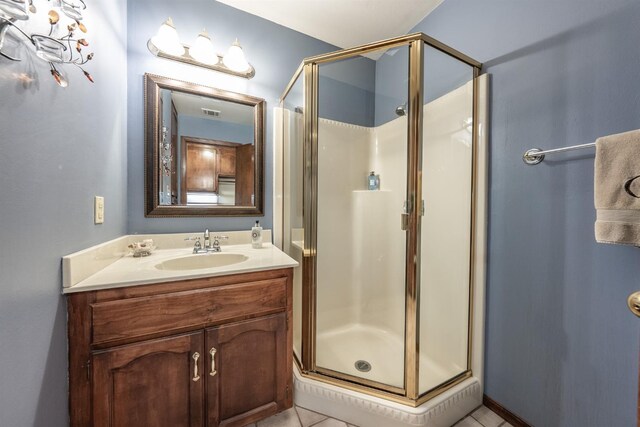 bathroom featuring vanity, tile patterned floors, and a shower with shower door