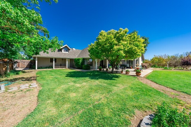 rear view of property featuring a yard and a patio area