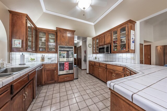 kitchen with ceiling fan, light tile patterned flooring, backsplash, stainless steel appliances, and tile countertops