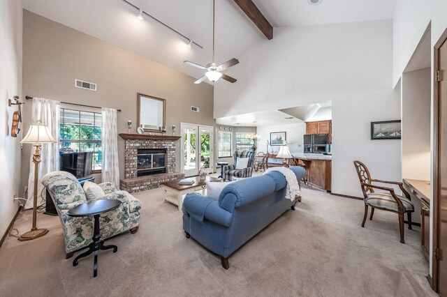 living room with ceiling fan, a fireplace, plenty of natural light, and high vaulted ceiling