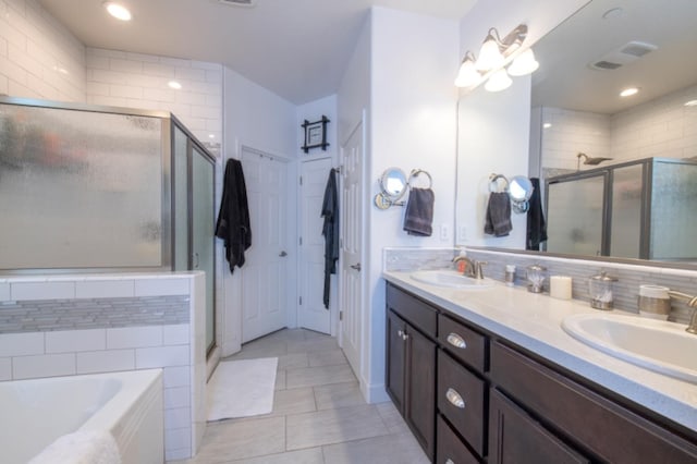 bathroom with tile walls, tile floors, dual vanity, and independent shower and bath