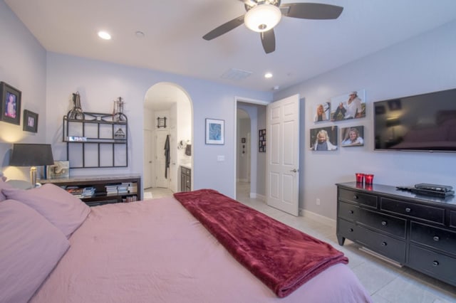 bedroom featuring ensuite bathroom, ceiling fan, and light tile floors