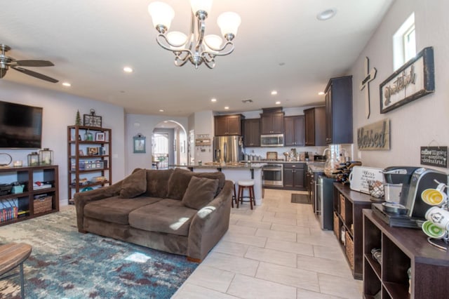 living room with ceiling fan with notable chandelier, sink, and light tile floors