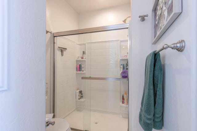 bathroom with an enclosed shower and toilet