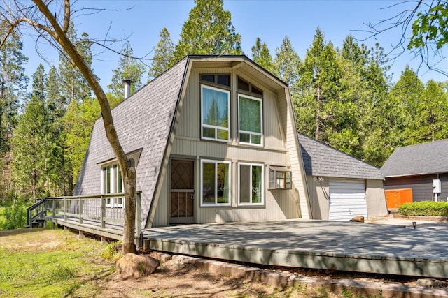 view of front of property featuring an outdoor structure, a garage, and a deck