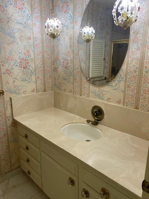 bathroom featuring an inviting chandelier, vanity, and tile floors