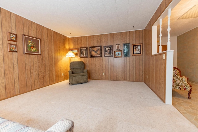 sitting room featuring wooden walls and carpet flooring