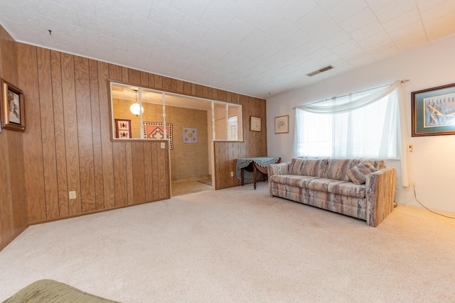 carpeted living room featuring wooden walls