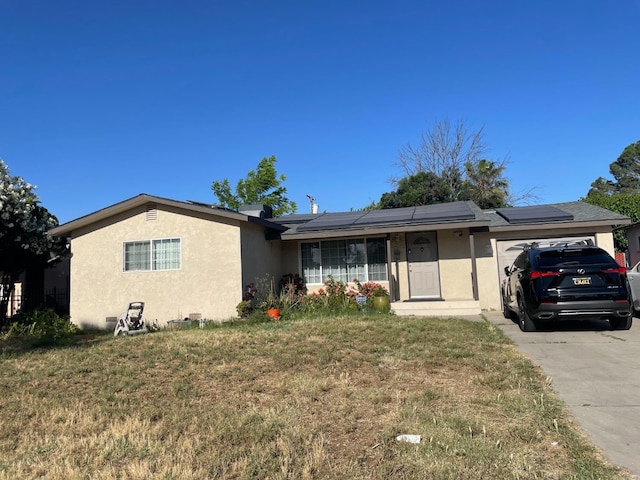 ranch-style house with a garage, a front lawn, and solar panels